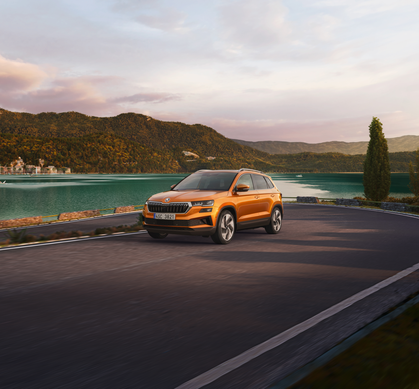 Skoda qui roule sur la route avec un lac en arrière plan