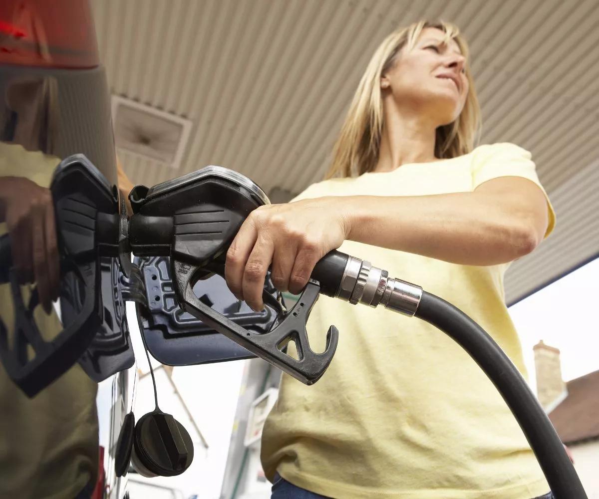 Femme à la pompe tenant un pistolet Diesel