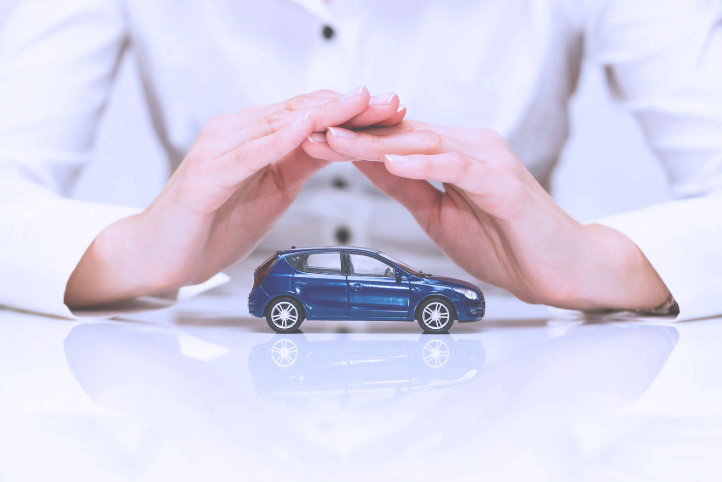 Concept d'assurance automobile - femme qui protege une voiture avec ses mains